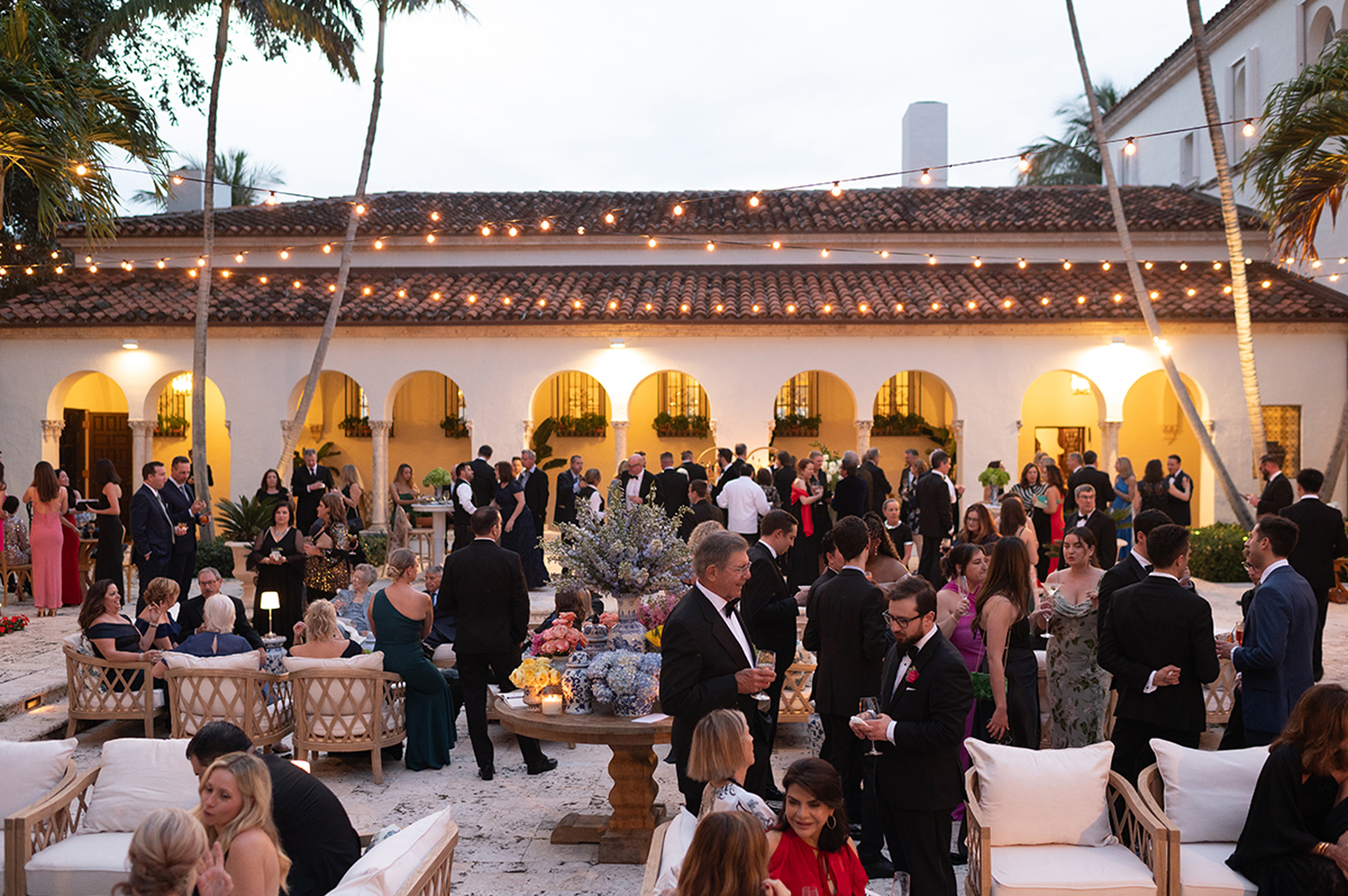 Guests gathering during an elegant courtyard cocktail hour before a luxury wedding reception